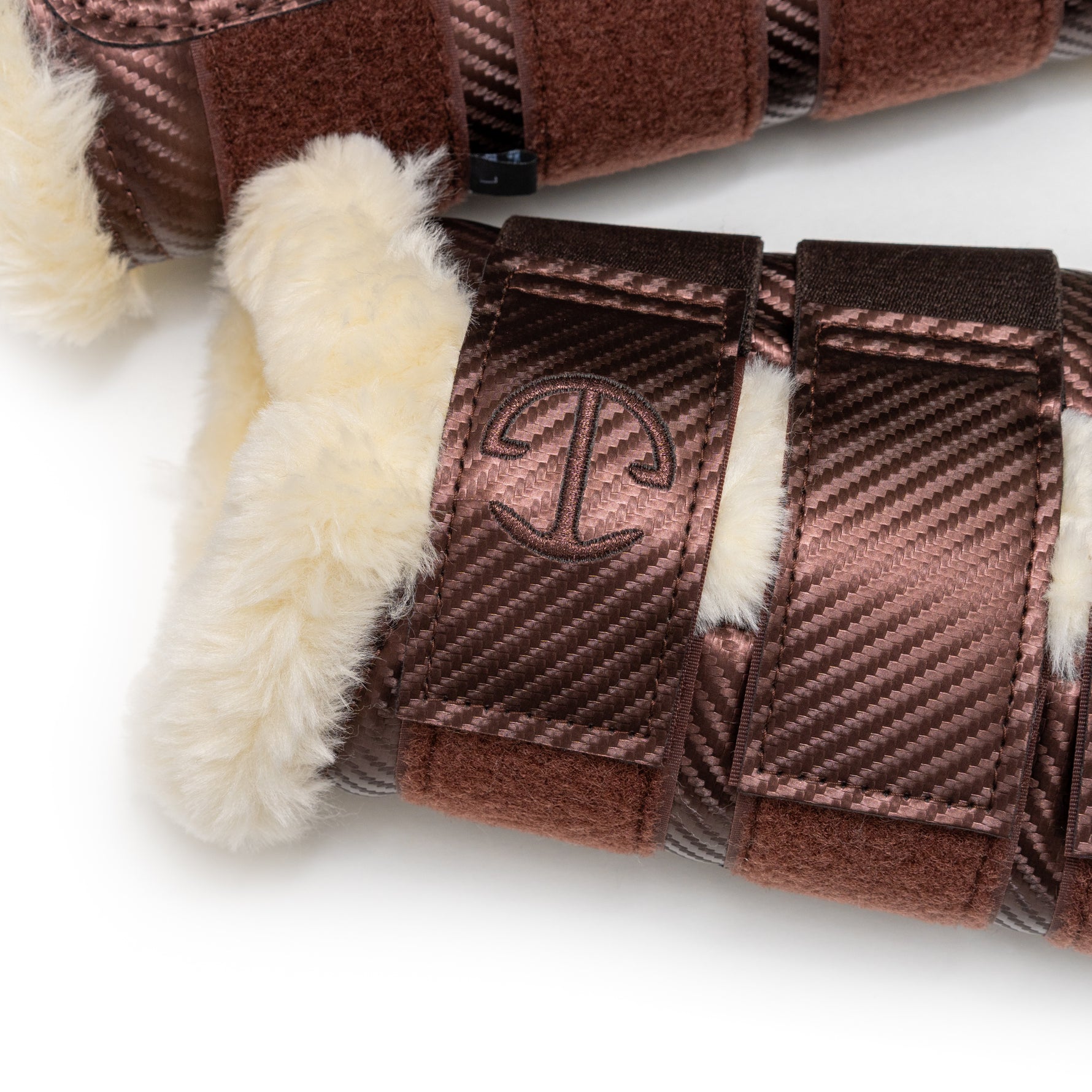 Close-up of brown brushing boots with  Halter Ego brand logo on a white background